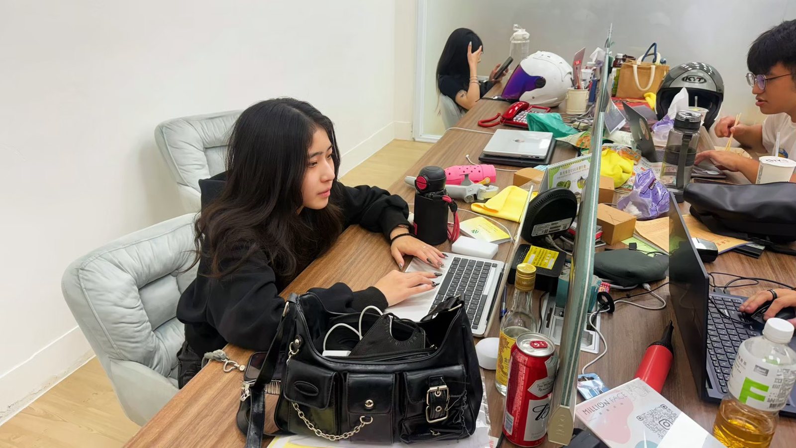 實習生在辦公桌前使用筆電工作