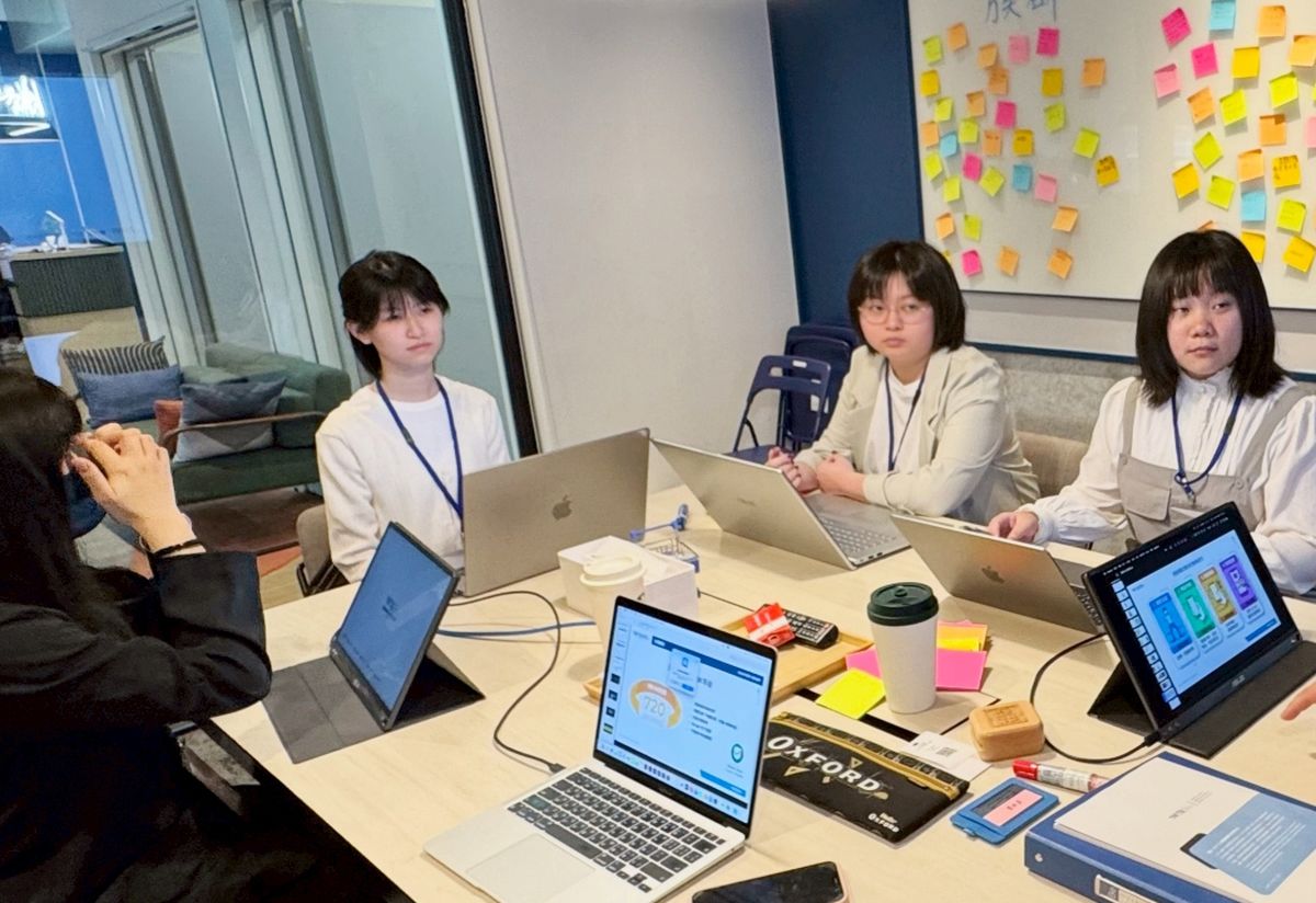 學生以筆電與平板展示原型並進行小組討論